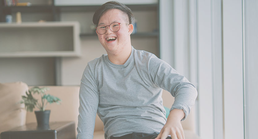 Asian man with glasses laughing.